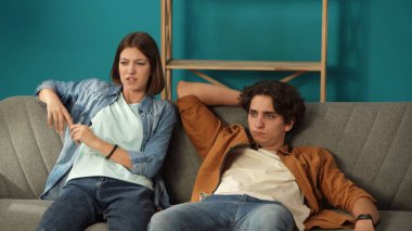 Yeni eve taşınma ve kiralama konsepti. Taşınmak ve taşınmak. Oturma odasının yakın çekimi. Bir adam ve bir kadın yeni dairede kanepede uzanıyorlar. Paketleri açtıktan sonra yorgun görünüyorlar..