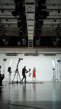 Music Clip Studio Set: Çağdaş Şehir Arkaplanı ile Sahnede Üç Profesyonel Dansçıyla Hip Hop Video Dans Sahnesi Çekimi. Sahne arkasında yönetmen ve kameraman.