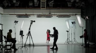 Music Clip Studio Set: Çağdaş Şehir Arkaplanı ile Sahnede Üç Profesyonel Dansçıyla Hip Hop Video Dans Sahnesi Çekimi. Sahne arkasında yönetmen ve kameraman.