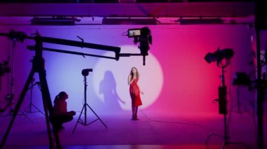 Beyaz siklonamalı profesyonel film köşkü. Bir klip çekimine hazırlanma süreci. Yönetmen, Kameraman ve ekibi sahne arkasında.