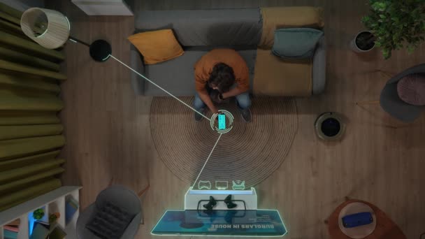 智能家居和现代技术的概念 房间里的男性画像 男人坐在沙发上 用智能手机上的应用程序打开家用电器的头像 物体上的信息数字图像 — 图库视频影像