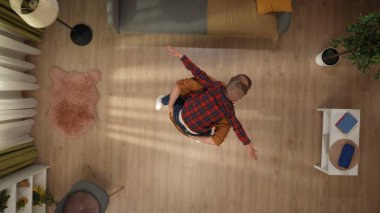 Aile bağı ve ebeveynlik yaratıcı konsepti. Evde birlikte vakit geçiririz. Üst kattaki apartman dairesinde, baba odada duruyor ve oğlunu sırtında tutuyor, çocuk da babasından destek alıyor..