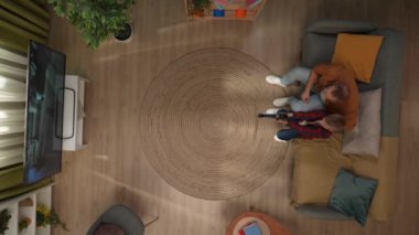 Aile ilişkileri ve ebeveynlik reklamları. Ailecek vakit geçireceğiz. Oda manzarası, kanepede oturan baba ve oğul, video oyunu oynayan çocuk, çocuğun kazanmasına yardım eden baba..