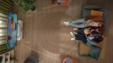 Aile ilişkileri ve ebeveynlik reklamları. Ailecek vakit geçireceğiz. Oturma odasının en iyi manzarası. Anne, baba ve oğul kanepede oturur, televizyon izler, patlamış mısır yer ve konuşurlar..