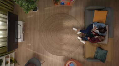 Aile ilişkileri ve ebeveynlik reklamları. Ailecek vakit geçireceğiz. Oturma odasındaki ana oğul kanepede oturup tablette video izleyip bir şeyler konuşuyorlar..