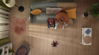 Aile ilişkileri ve ebeveynlik reklamları. Ailecek vakit geçireceğiz. Oturma odası manzaralı, baba ve küçük oğlu uzaktan kumandalı robot oyuncaklarla oynuyor, birlikte eğleniyorlar..