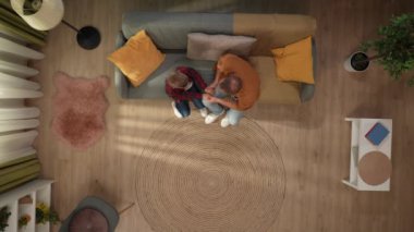 Aile ilişkileri ve ebeveynlik reklamları. Ailecek vakit geçireceğiz. Oturma odasının en iyi manzarası. Baba ve oğul koltukta oturuyor, baba çocukla el ele tutuşuyor ve sarılıyorlar..