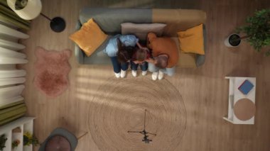 Aile ilişkileri ve ebeveynlik reklamları. Ailecek vakit geçireceğiz. Oturma odasının en iyi manzarası, anne baba ve küçük oğlu kanepede oturup akıllı telefondan selfie çekiyorlar..