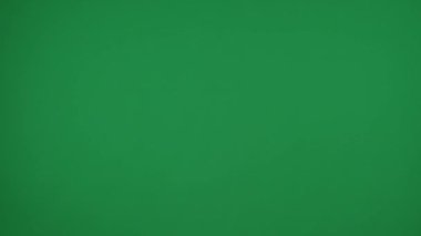 Yeşil arka plandaki çerçevede, topal anahtar kadın elleri düz, boş kağıt yaprakları, sarı ve turuncu. Onları kaldırdı ve kameraya gösterdi. Orta çerçeve.