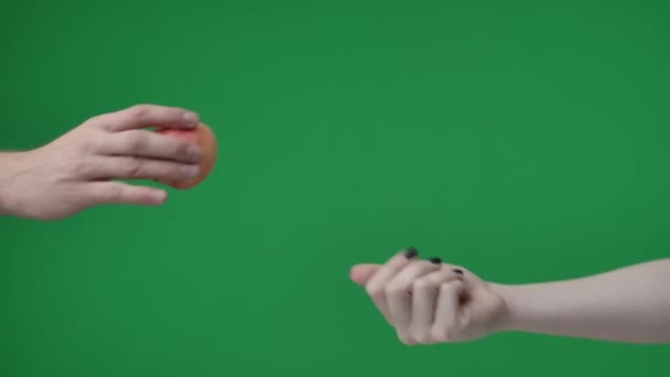 緑色の背景にある クロメイクの写真です 2人で マニキュアを持った女性がリンゴを握ります 男はそれを彼女の手を覆っている 彼らは共有し 治療を共有しています — ストック動画