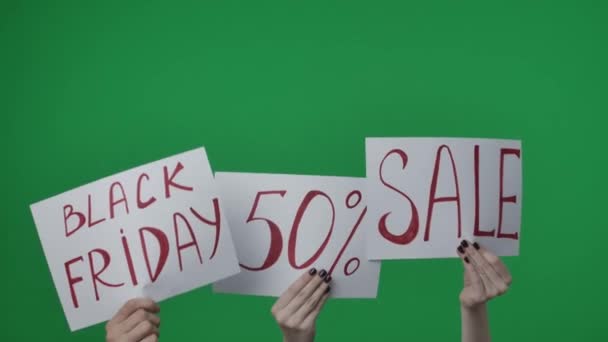 緑色の背景にある クロメイクの写真です 女性は手を挙げてポスターを保持し 碑文付きのシート ブラックフライデー 購入するコールを表示し — ストック動画