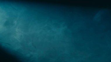 Siyah arka planda mavi dumanı kaotik bir şekilde harmanlayan tütsülerin soyut arkaplanı. Mavi neon ışıktaki gerçekçi sis yaklaşıyor. Doku ve soyut sanat. Boşluğu kopyala