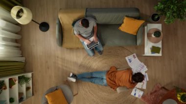 Homoseksüel bir çiftin birlikte vakit geçirdiği en iyi görüntü. Biri dizüstü bilgisayarda çalışıyor, ortağı grafikler ve çizelgeler üzerinde çalışıyor. LGBT, eşitlik, eğitim içeriği, gurur.