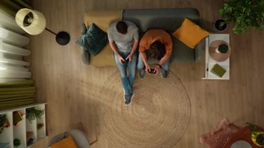 Evde homoseksüel bir çiftin en iyi görüntüsü. Kanepede oturuyorlar, ellerinde av köpekleri ile video oyunu oynuyorlar, eğleniyorlar ve kavga ediyorlar. LGBT, eşitlik, eğitim, gurur.