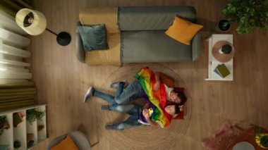 Eşcinsel bir çiftin yerde yan yana yatıp LGBT bayrağına sarılmış akıllı bir telefonla birbirlerine sarılıp selfie çekerek aşkı, eşitliği, özgürlüğü teşvik ettiği en iyi görüntü. Eğitim içeriği, gurur.
