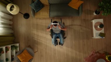 Top view engelli bir yetişkini, tekerlekli sandalyede oturan, kulaklık takan ve müzik dinleyen bir adamı çekiyor. Özürlülük, bağımsızlık ve