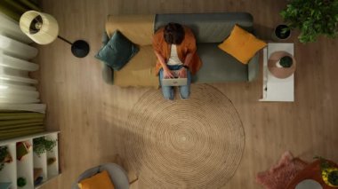 Evde homoseksüel bir çiftin en iyi görüntüsü. Bir tanesi kanepede oturuyor, dizüstü bilgisayarla çalışıyor. Ortağı kadraja giriyor. Sarıldılar ve konuştular. LGBT, eşitlik, eğitim, gurur.
