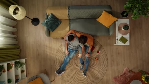집에서 동성애 커플의 그들은 바닥에 Tv를 간식을 마시고 포옹하고 적극적으로 — 비디오