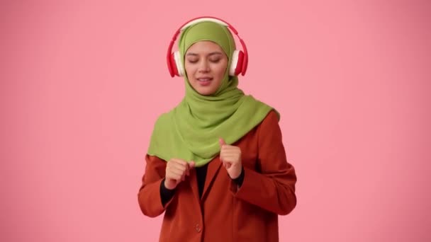 中等尺寸的独立录像拍摄了一个戴着头巾 头戴面纱的年轻貌美女子 她在听音乐 然后把耳机摘下来 弄糊涂了 文化多样性的场所 — 图库视频影像