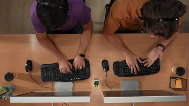 オフィス チームワークおよび現代ビジネス プロセスの創造的な概念 コールセンター部 コンピュータ付きの机のトップビュー ヘッドセットの男性労働者は クライアントと話す 仕事を完了し ハイ5 — ストック動画