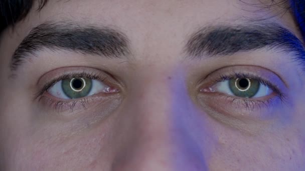 一个年轻人的眼睛 宏观拍摄 智能手机发出的蓝光 电脑屏幕反射在男人的眼睛里 小玩艺儿滥用概念 — 图库视频影像