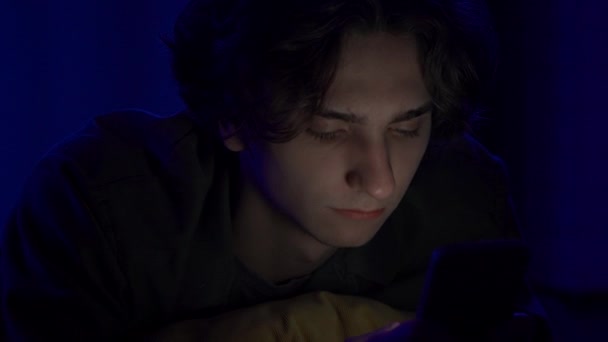 Ein Junger Mann Schreibt Auf Seinem Smartphone Sms Während Nachts — Stockvideo