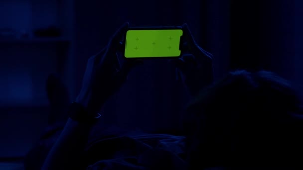 Homem Deitado Sofá Noite Segurando Horizontalmente Smartphone Com Uma Tela — Vídeo de Stock