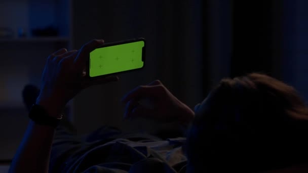Homem Deitado Sofá Noite Segurando Horizontalmente Smartphone Com Uma Tela — Vídeo de Stock