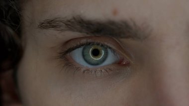 Genç bir adamın gözü makro atış. Cihazların uzun süre kullanılmasından dolayı büyümüş gözbebekleri. Kuru göz sendromu. Sağlık kavramı