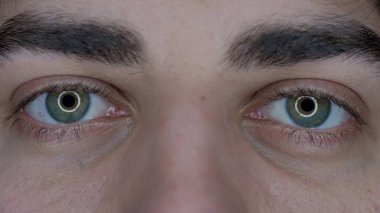 Makro şat bir adamın gözleri. Cihazların uzun süre kullanılmasından dolayı büyümüş gözbebekleri. Kuru göz sendromu. Sağlık kavramı