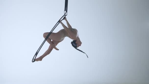 在一个金属旋转结构的月亮上 体操女子在空中的一只胳膊上表演人渣 白人背景 — 图库视频影像