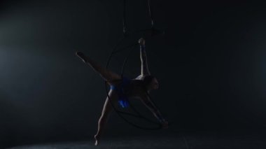 Ritmik jimnastikçi kız, metal bir yapı uydusunda tek koluyla havadaki pisliği canlandırıyor.