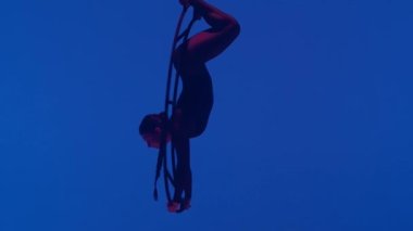 Ritmik jimnastikçi kız, metal bir yapı uydusunda tek koluyla havadaki pisliği canlandırıyor.