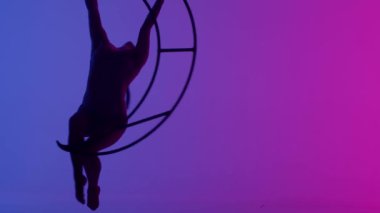 Ritmik jimnastikçi kız, metal bir yapı uydusunda tek koluyla havadaki pisliği canlandırıyor.