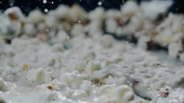 Patlamış mısır kızartma tavasında pişirilir. Arka planda ayçiçeği yağı ile yüksek hızlı kamerayla çekilir..