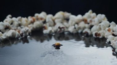 Patlamış mısır kızartma tavasında pişirilir. Arka planda ayçiçeği yağı ile yüksek hızlı kamerayla çekilir..