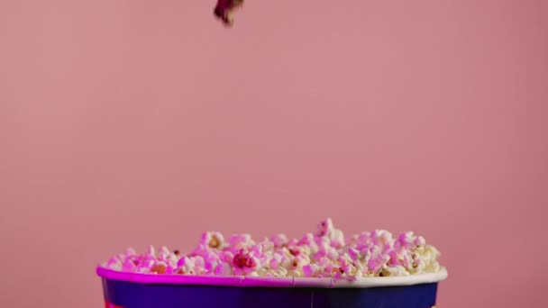 Повільний Рух Попкорну Падає Всередину Сумки Рожевий Фон — стокове відео