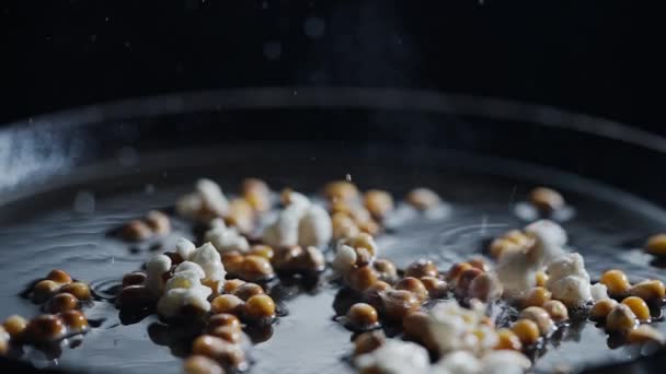 Popcorn Wordt Gekookt Een Koekenpan Met Zonnebloemolie Zwarte Achtergrond Schieten — Stockvideo