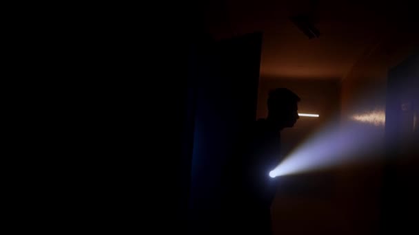 懐中電灯のある男が暗い廊下を歩いている — ストック動画