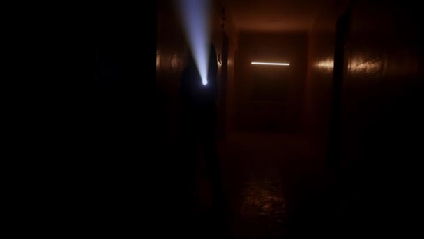 懐中電灯のある女性が暗い廊下を歩く — ストック動画