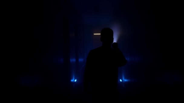 懐中電灯のある男が暗い廊下を歩いている バックビュー — ストック動画