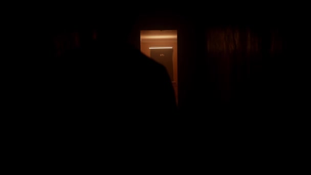 Silhouette Man Walks Dark Corridor She Walks Door Orange Light — Stock Video
