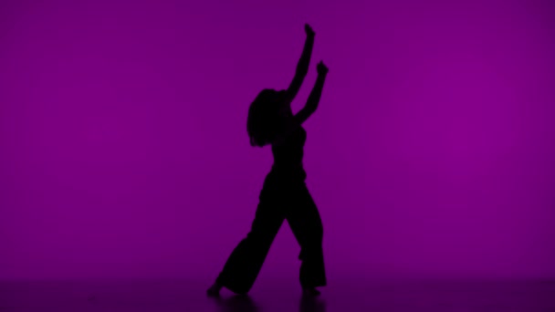 실루엣의 보라색 배경에있는 프레임에서 날씬하고 아름다운 스타일의 움직임을 보여줍니다 그것은 — 비디오