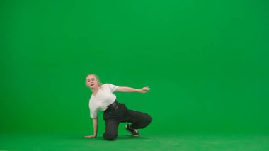 Yeşil arkaplanda, kromakey. Genç, narin, güzel bir kız dans ediyor. Caz funk yönünde çeşitli dans hareketleri sergiliyor. Ritmik, plastik. Genel plan.