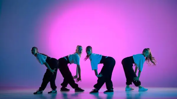 紫色の背景のフレームでは 魅力的な女の子で構成されるダンスグループ 彼らはジャズファンクの方向にダンスの動きを示しています 一般プラン — ストック写真