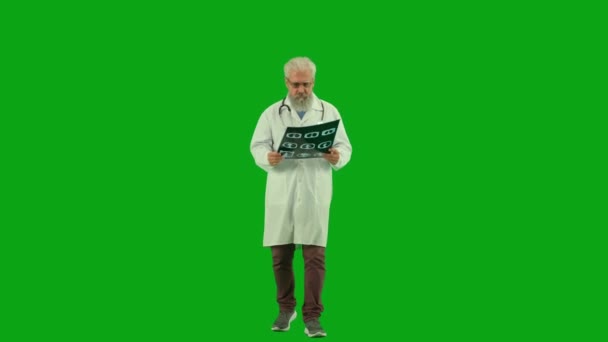 保健和医疗咨询广告概念 彩色键绿色屏幕上的老年男性医师画像 穿着制服走来走去 拿着一张X光照片的资深医生和主治医生 — 图库视频影像