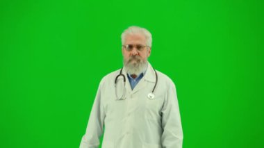 Sağlık ve tıbbi danışmanlık reklam konsepti. Krom anahtar yeşil ekranda insan sıhhiyesinin portresi. Üniformalı kıdemli doktor klinikte dolaşıp etrafa bakıyor..
