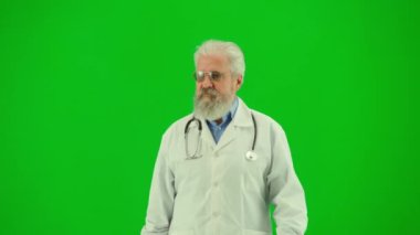 Sağlık ve tıbbi danışmanlık reklam konsepti. Krom anahtar yeşil ekranda insan sıhhiyesinin portresi. Üniformalı kıdemli doktoru kapatın. İnsanları selamlayın. Dostça bir ifade..