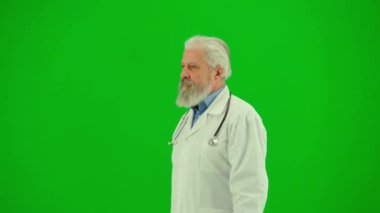Sağlık ve tıbbi danışmanlık reklam konsepti. Krom anahtar yeşil ekranda insan sıhhiyesinin portresi. Beyaz önlüklü kıdemli doktor yürüyor ve etrafa bakıyor..