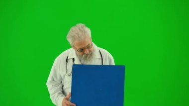 Sağlık ve tıbbi danışmanlık reklam konsepti. Krom anahtar yeşil ekranda insan sıhhiyesinin portresi. Beyaz önlüklü, elinde reklam panosu olan kıdemli doktoru kapat ve gülümseyerek onu işaret et..